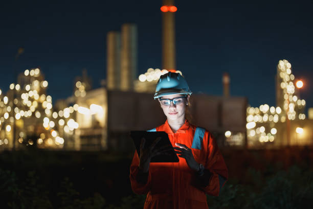 istock Female petroleum oil refinery engineer working with tablet to check safety quality control of oil and gas plant at night. 2177267915