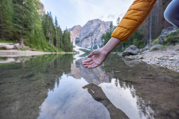 istock Hand Touching Clear Mountain Lake Water 2177271556