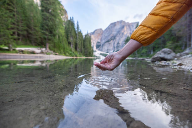 istock Hand Touching Clear Mountain Lake Water 2177271588