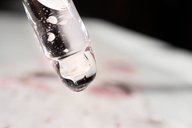 Pipette with essential oil on bottle blurred background