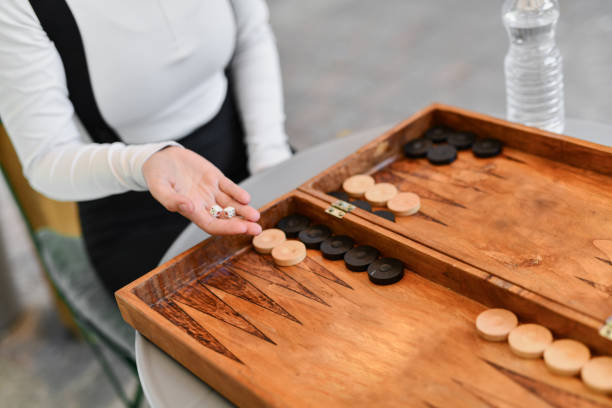 istock Female's Turn to Throw the Dices While Playing Backgammon Outdoors 2177277578