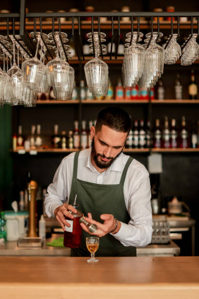 istock Skilled bartender prepares a cocktail at a stylish bar during a vibrant evening in a bustling city 2177278803