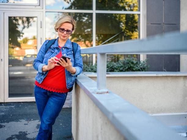 istock Mature woman using a smart phone on the street 2177279009
