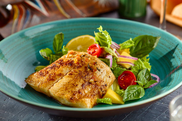 istock White Fish Steak with Fresh Vegetable Salad Delight in Vibrant Cerulean Dish – Bright and Gourmet Presentation 2177279347