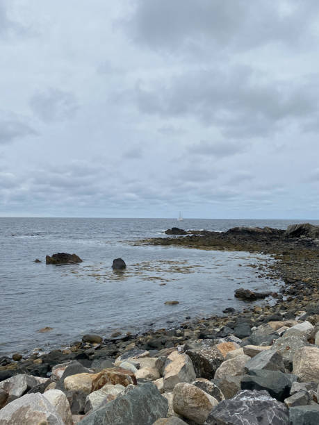 istock Calm waters on rocky Maine coast with sail boat 2177279712