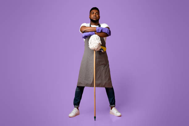 On Guard Of Cleanliness. Professional African American Cleaner Posing With Mop Over Pink Background In Studio, Ready For Big Cleaning