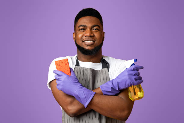 istock Confident Black Janitor Wearing Apron With Sponge And Spray Detergent In Hands 2177280363