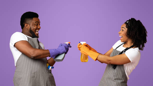 istock Joyful couple fooling during spring-cleaning, aiming detergent sprayers at each other 2177280367