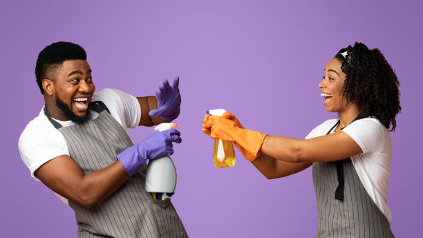 istock Cheerful Afro Couple Playing With Spray Detergents, Playfully Aiming At Each Other 2177280377