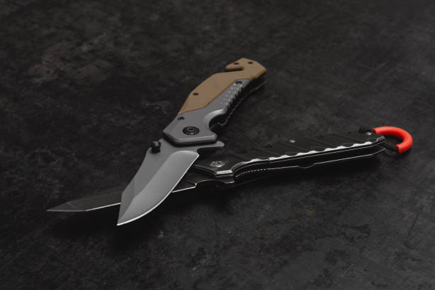 istock Two opened tactical military knives with sharp blade. Tool on dark concrete background. 2177280875