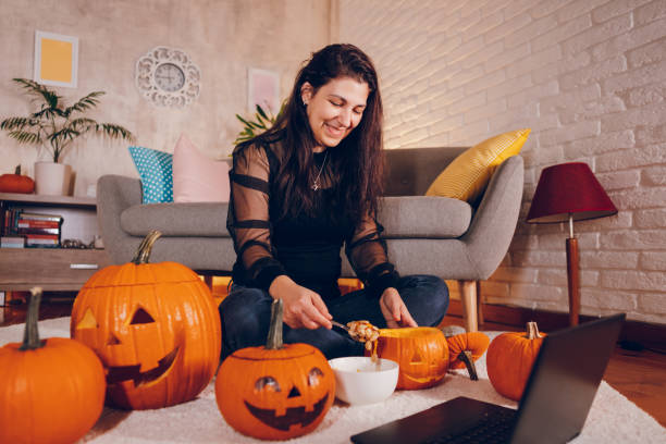 istock Woman dig pumpkins and have video call for Halloween. 2177283949