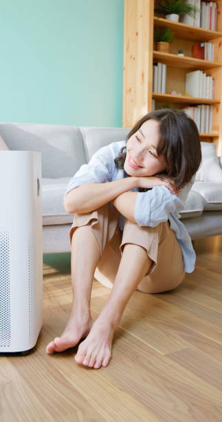 istock woman use air purifier home 2177285086