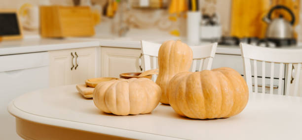 istock Pumpkins on white table on background of blurred kitchen 2177286291