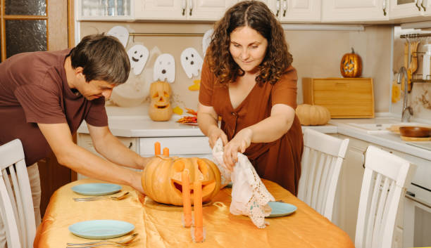 istock Middle-aged couple sets the table for Halloween party 2177286336