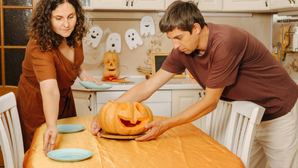 istock Middle-aged couple sets the table for Halloween party 2177286340