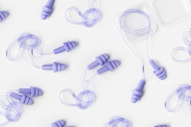 istock Violet purple color earplugs as minimal trend pattern on white, reusable silicone, rubber ear plug in box against noise, protect hear, for swim, sleep, rest. Creative aesthetic flat lay, 2177287439