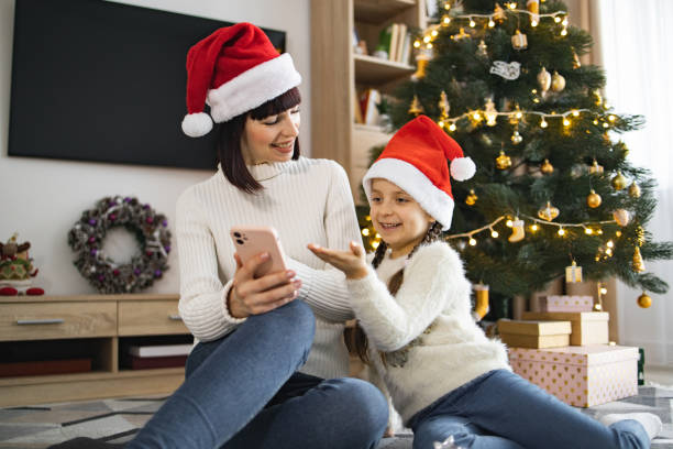 istock Mother and daughter enjoying Christmas time at home using phone 2177287647