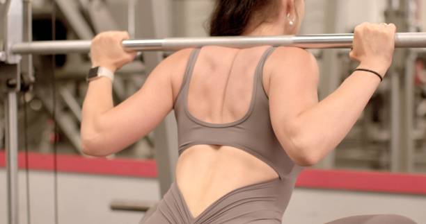 istock A woman athletic attire doing squats barbell gym, showing dedication 2177288106