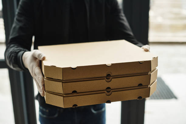 istock Delivery person carrying pizza boxes to a bustling modern office during lunchtime hustle 2177288638