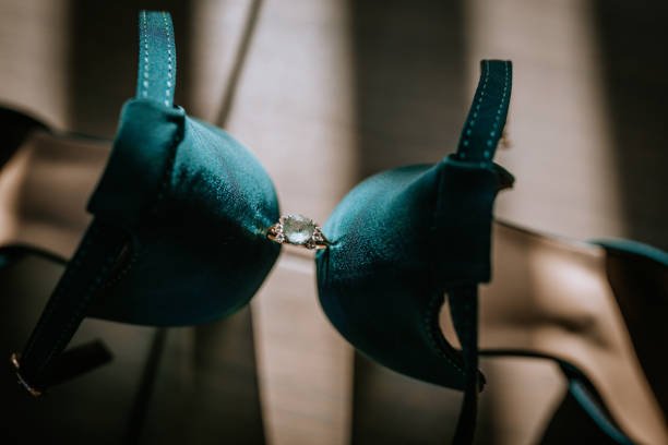 A sparkling engagement ring sits between two elegant teal high heels, creating a sophisticated and romantic bridal accessory arrangement.