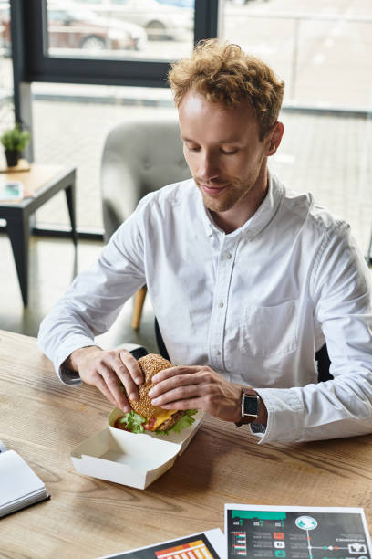 istock Redhead businessman working on a project while enjoying lunch in a chic office 2177290672