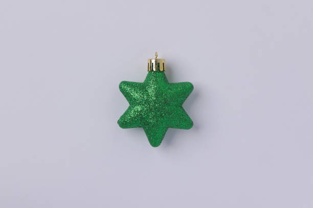 istock A green star with glitter on it isolated in white background. Sparkle star ornament for Christmas tree decoration. 2177293011