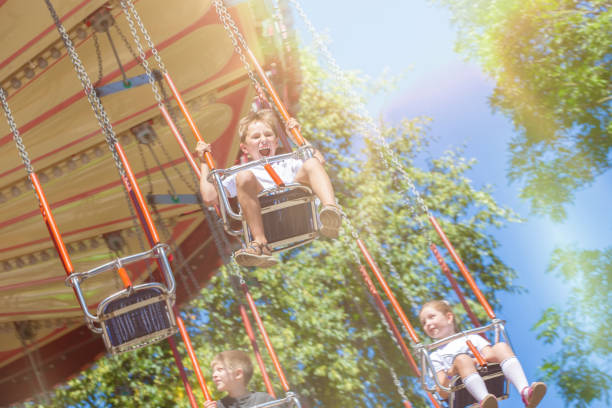 istock A little boy rides on a chain carousel in the morning sun. 2177293410