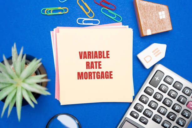 istock Variable rate mortgage concept. Type of home loan in which the interest rate is not fixed. Real estate, business and finance concept. Miniature houses, magnifying glass, calculator and notes 2177293960