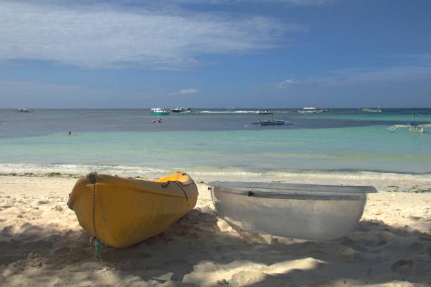 istock Two plastic boats on sandy beach with ocean distance in background. 2177294486