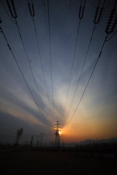 High voltage electricity pylons and power lines at sunset
