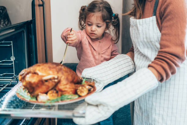 istock Mother and daughter preparing turkey for Thanksgiving 2177303147