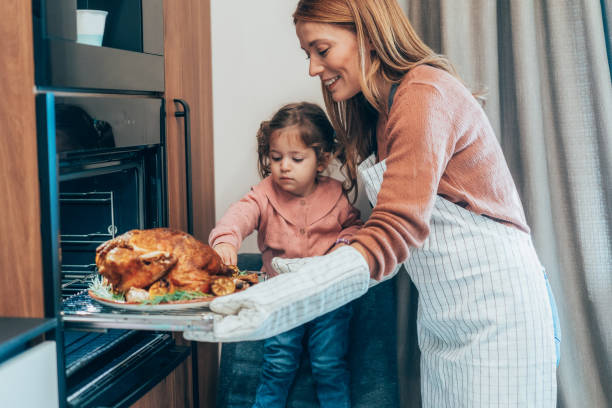 istock Mother and daughter preparing turkey for Thanksgiving 2177303156