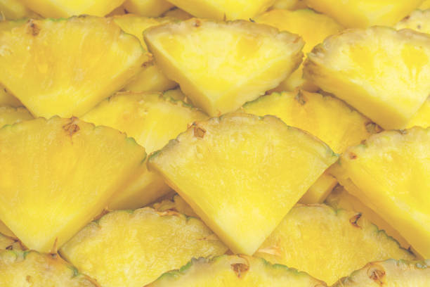 Pineapple juicy yellow slices as a background. Top view.