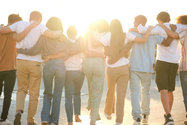 istock Group of diverse young people walking together outdoors at sunset 2177304965
