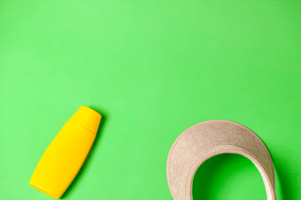 istock Jar of yellow sunscreen and visor on green background. 2177305049