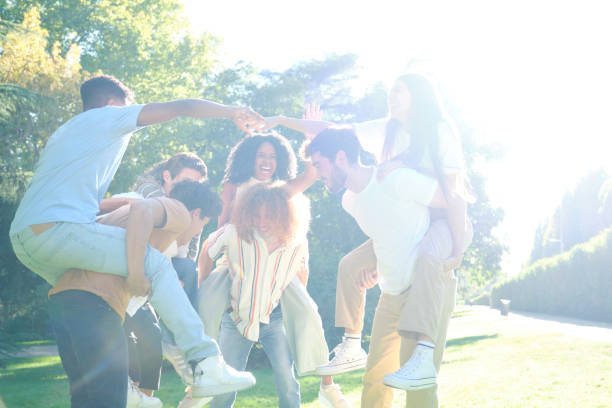 istock Group of friends having fun piggybacking in a park 2177305448