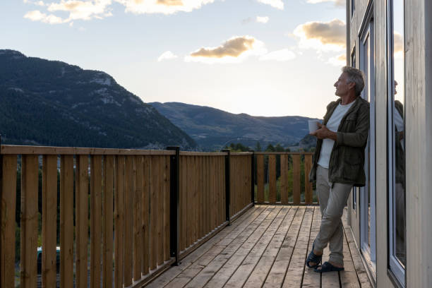 istock Mature man watches sunrise from cabin deck with hot beverage 2177305763