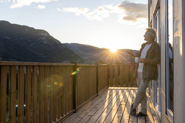 istock Mature man watches sunrise from cabin deck with hot beverage 2177305838