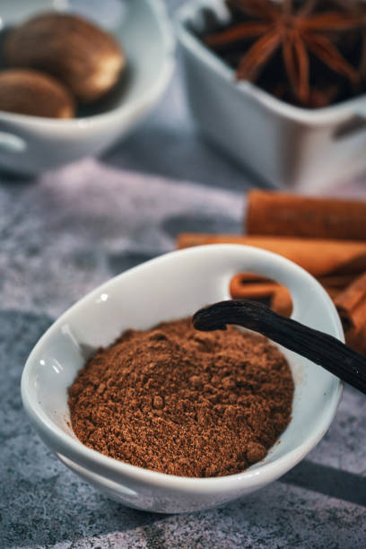 Vanilla pods undergo a aging process until they are browned with vanilla flowers on a white background.