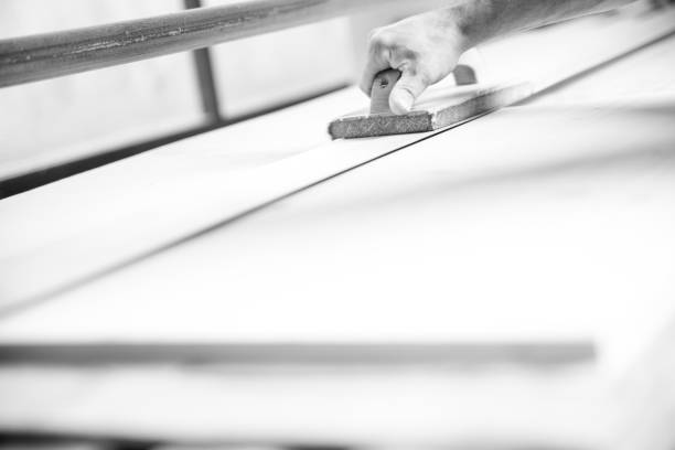 istock Black and white picture of Carpenter sanding wood using sandpape 2177308454