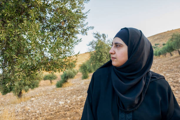 istock Muslim woman praying next to olive tree for god blessing 2177312327