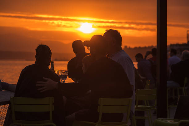 Seattle, USA - Jun 8, 2023: Late in the day a vivid sunset over Elliott bay with people enjoying the view from pier 62.