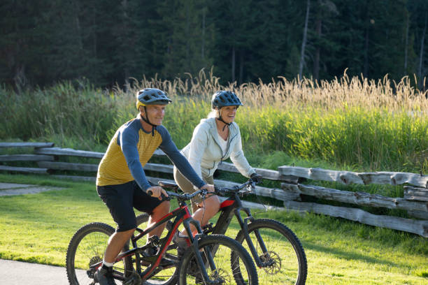 istock Mature couple bike on paved pathway 2177314423