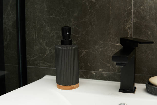 istock A sleek black soap dispenser with a textured finish and a wooden base 2177318049