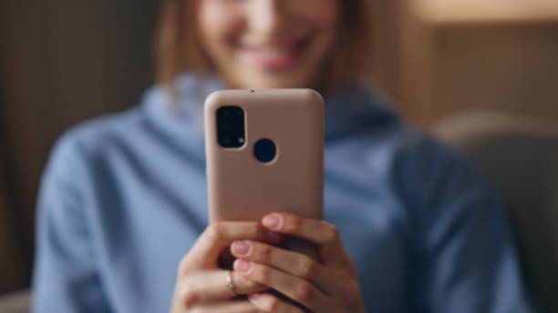 istock Smiling girl typing sms on smartphone sitting comfortable apartment closeup. 2177318062
