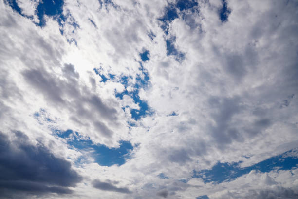 A dramatic sky with thick clouds partially covering the sun, creating a captivating play of light and shadows.