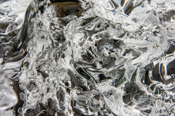 A full frame close up of the surface ice from a melting glacier that makes a good black and white abstract background