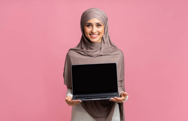 istock Smiling Arabic Girl In Hijab Holding Laptop Computer With Black Screen 2177322152