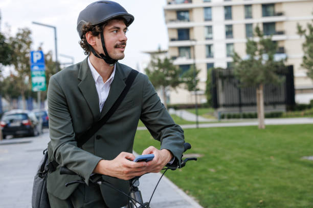 istock A businessman checking his e-mails on smart phone while cycling through the city 2177323010