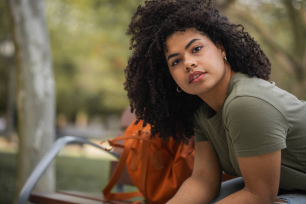 istock Student with curly hair looking at camera sitting outdoors 2177323059